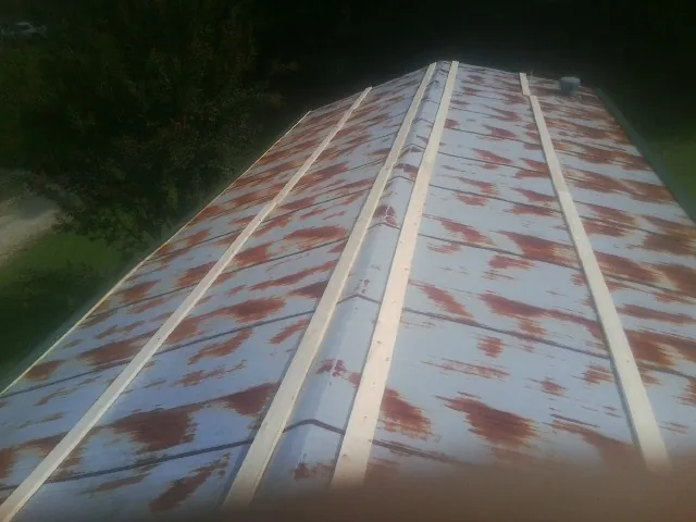 Rusted metal roof panels with new wood purlins before replacement — Storm Damage Roof Repair in Keosauqua by Roofing Brothers